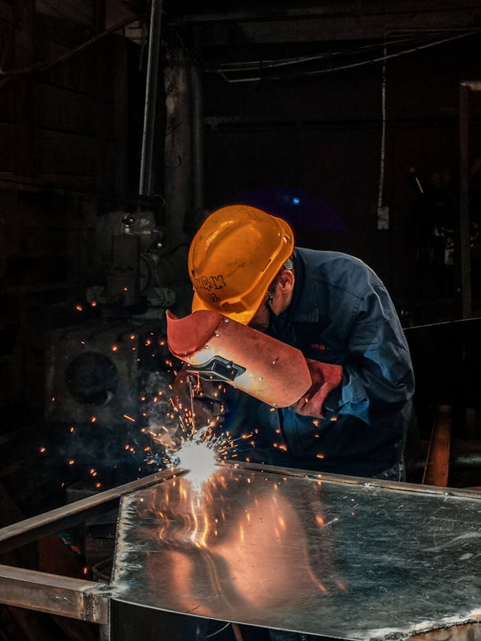 The Art of Drawing Readers In: Your attractive post title goes here A welder wearing protective gear works on metal in an industrial workshop, surrounded by sparks.